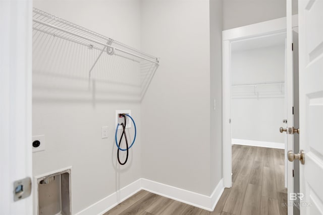 washroom featuring baseboards, light wood-style floors, hookup for a washing machine, and laundry area