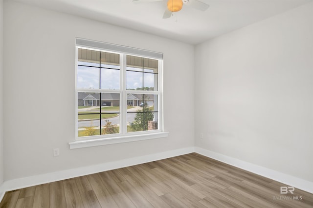 unfurnished room with baseboards, wood finished floors, and ceiling fan