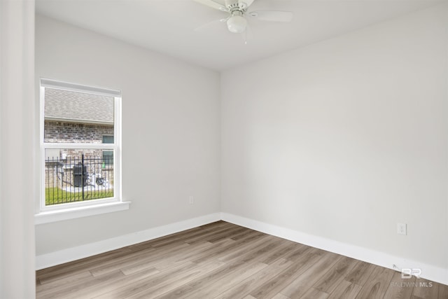 unfurnished room featuring a ceiling fan, wood finished floors, and baseboards