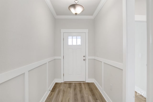 doorway with light wood finished floors and ornamental molding