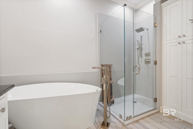 107 Fielding Pl, Mobile, AL 36608 - bathroom with a stall shower, a freestanding bath, and wood finished floors