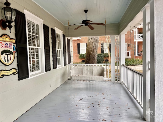 deck with ceiling fan and covered porch