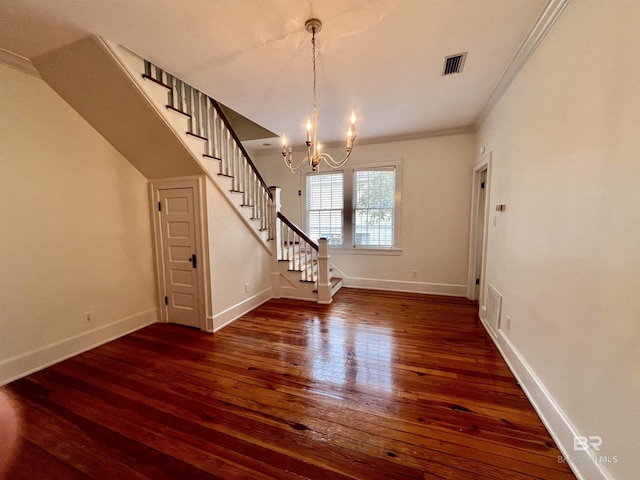 interior space with dark wood-type flooring, ornamental molding, and a chandelier