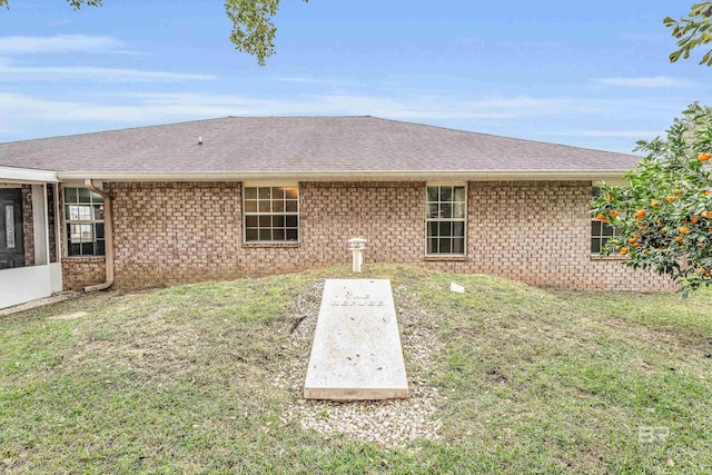 rear view of property featuring a lawn