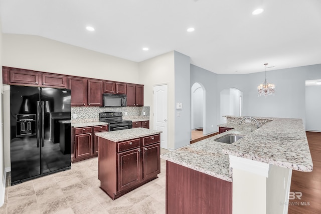 kitchen with black appliances, a center island with sink, sink, hanging light fixtures, and tasteful backsplash