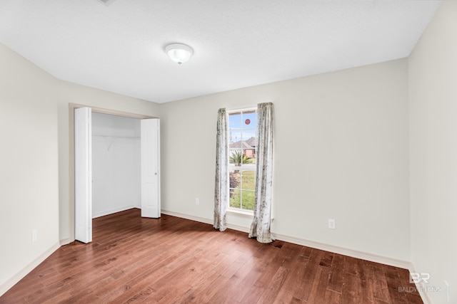 unfurnished bedroom featuring hardwood / wood-style floors and a closet