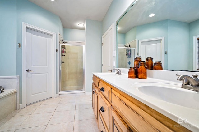 full bathroom with double vanity, a stall shower, tile patterned flooring, and a sink