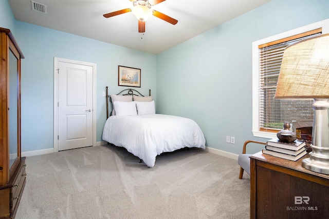 bedroom featuring light carpet, baseboards, visible vents, and a ceiling fan