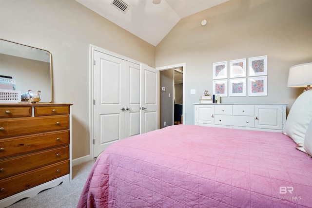 bedroom featuring vaulted ceiling, a closet, visible vents, and light colored carpet