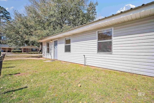 view of side of home with a yard