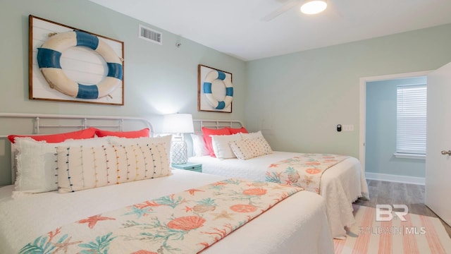 bedroom with wood finished floors, visible vents, baseboards, and ceiling fan