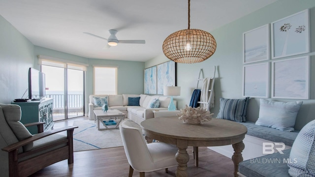 living area with wood finished floors and a ceiling fan