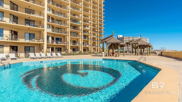 community pool featuring a gazebo, a patio, and fence