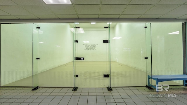 bathroom featuring tile patterned floors and a drop ceiling