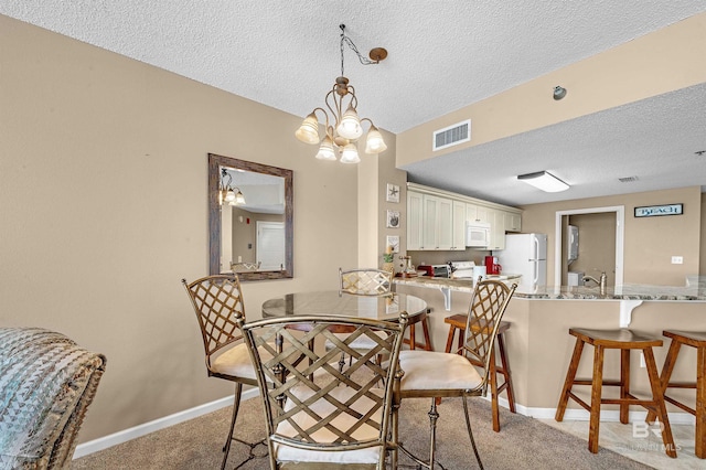 dining area featuring visible vents, light colored carpet, a textured ceiling, and baseboards