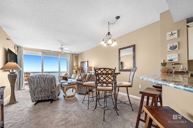 dining area with carpet flooring, a textured ceiling, a ceiling fan, and expansive windows