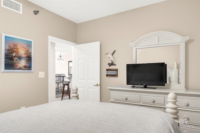 bedroom featuring an inviting chandelier and visible vents