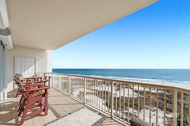 balcony featuring a water view and a beach view