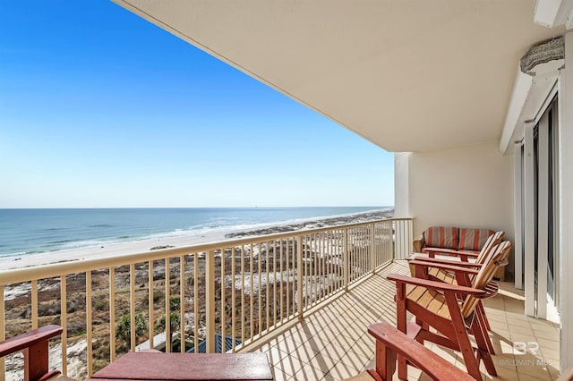 balcony with a water view and a view of the beach