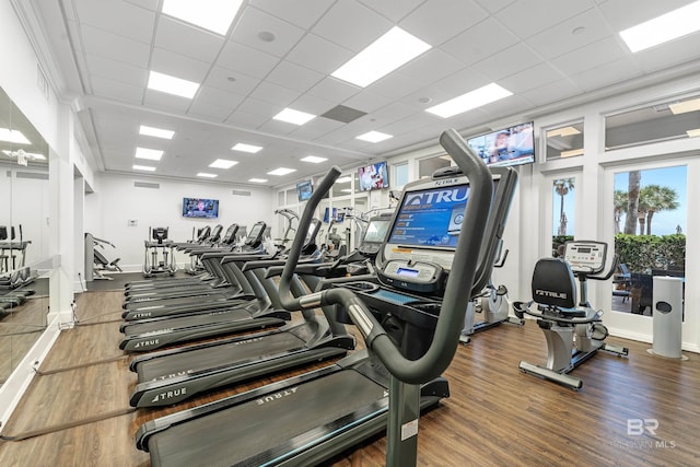 workout area with wood finished floors, visible vents, and a drop ceiling