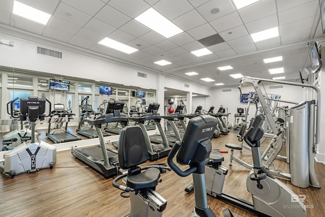 workout area featuring visible vents, a paneled ceiling, wood finished floors, and crown molding