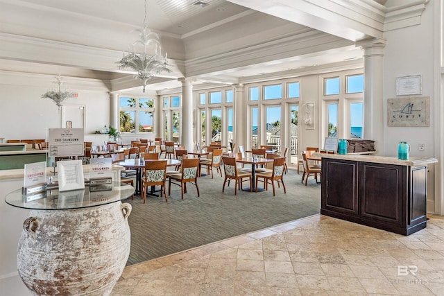 interior space featuring a wealth of natural light, an inviting chandelier, and ornate columns