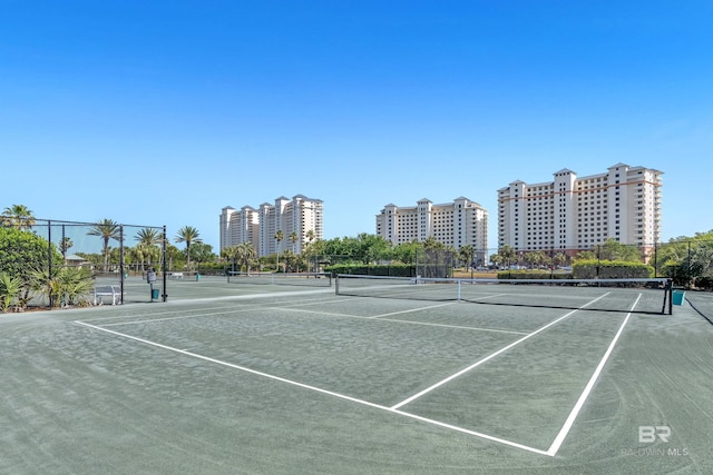 view of tennis court featuring a view of city, community basketball court, and fence