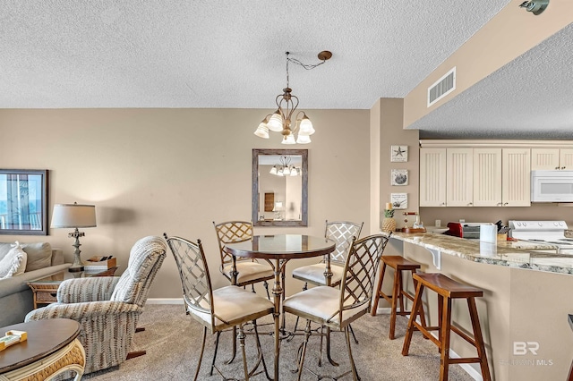 dining space with visible vents, baseboards, light colored carpet, a notable chandelier, and a textured ceiling