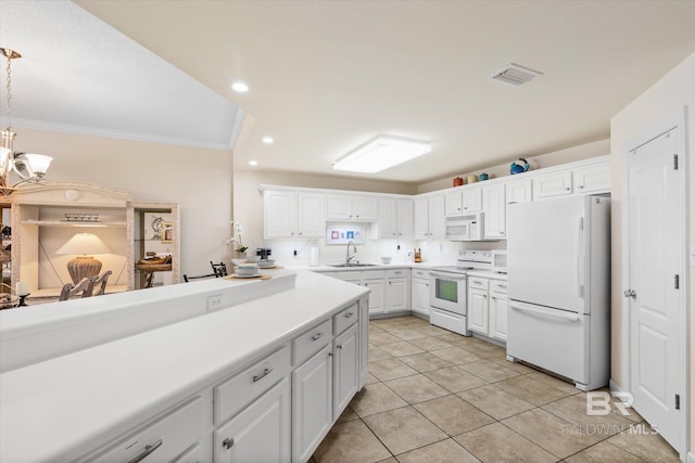 kitchen with light countertops, visible vents, ornamental molding, a sink, and white appliances