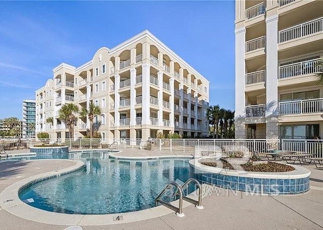 community pool featuring a patio area and fence