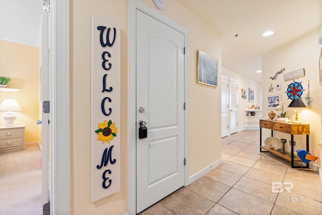 hallway featuring recessed lighting, light tile patterned flooring, and baseboards