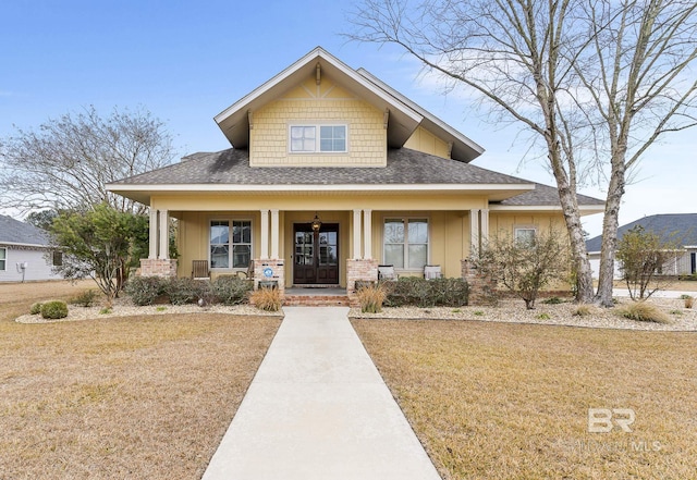 view of front of house with covered porch and a front lawn