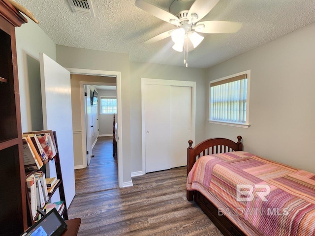 bedroom featuring hardwood / wood-style flooring, a closet, a textured ceiling, and ceiling fan