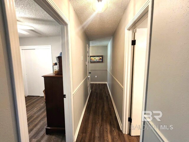 hallway featuring a textured ceiling and hardwood / wood-style flooring