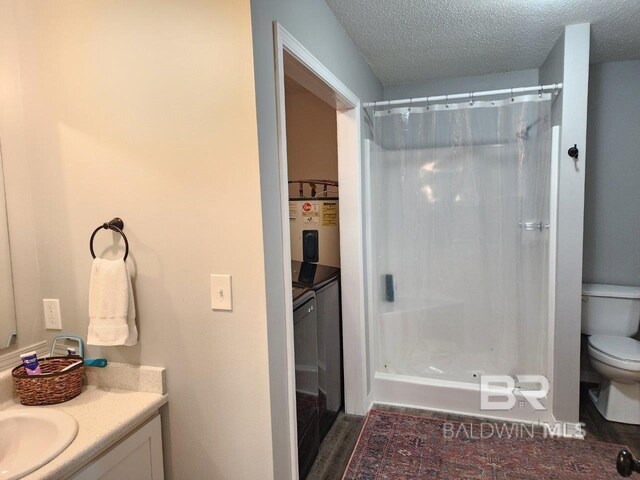 bathroom with a textured ceiling, toilet, vanity, and wood-type flooring