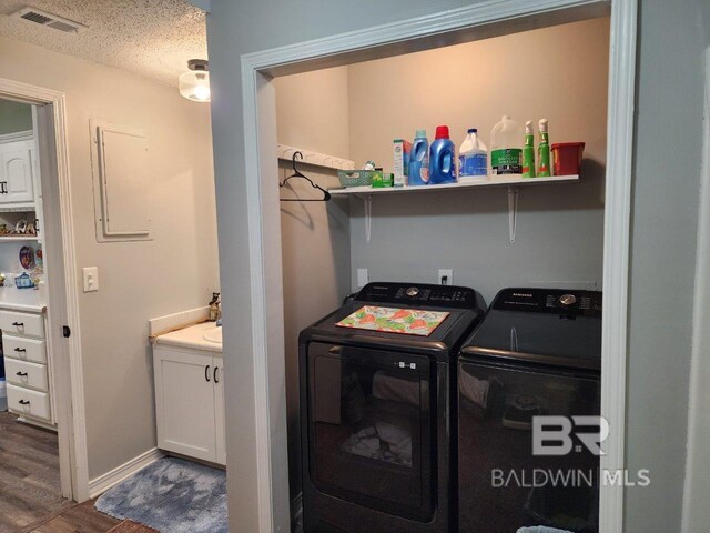 washroom with washer and dryer, hardwood / wood-style floors, and a textured ceiling