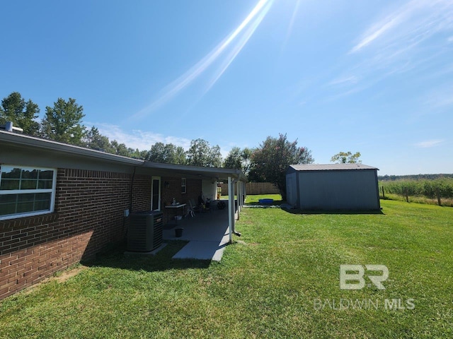 view of yard with a storage unit, central AC unit, and a patio area