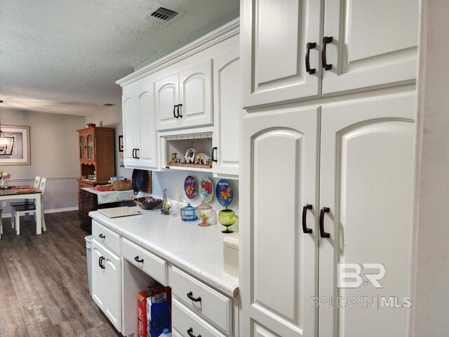 kitchen with white cabinets, a textured ceiling, and dark hardwood / wood-style floors