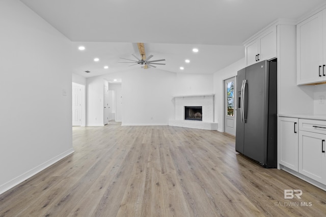 unfurnished living room featuring recessed lighting, a ceiling fan, baseboards, light wood-style floors, and a brick fireplace