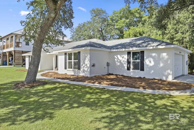 view of front of home with an attached garage, brick siding, and a front yard