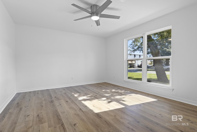 unfurnished room with light wood-style flooring, baseboards, and a ceiling fan