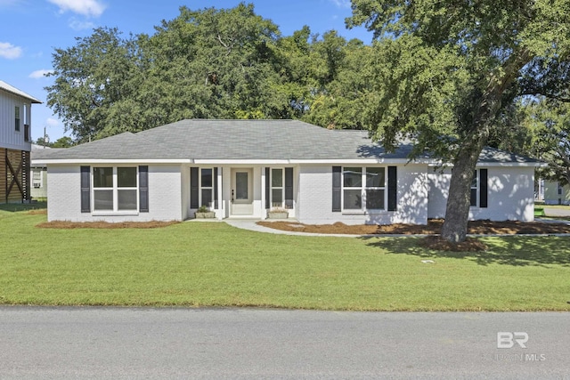 ranch-style home featuring brick siding and a front lawn