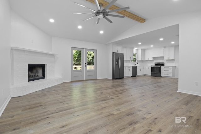 unfurnished living room with light wood-style floors, recessed lighting, lofted ceiling with beams, and baseboards