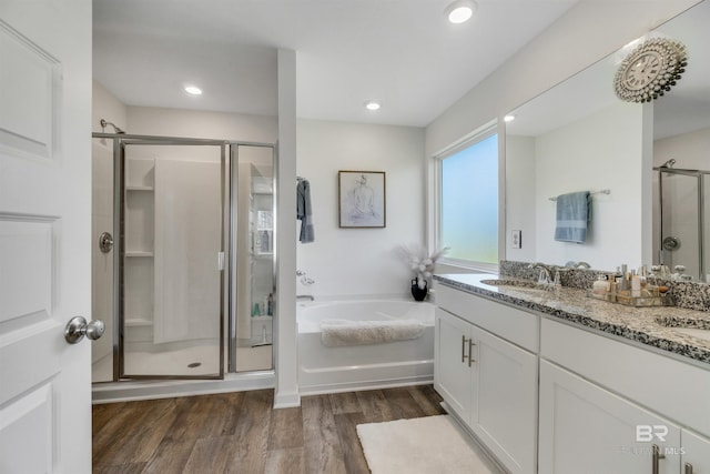 bathroom featuring hardwood / wood-style floors, vanity, and shower with separate bathtub