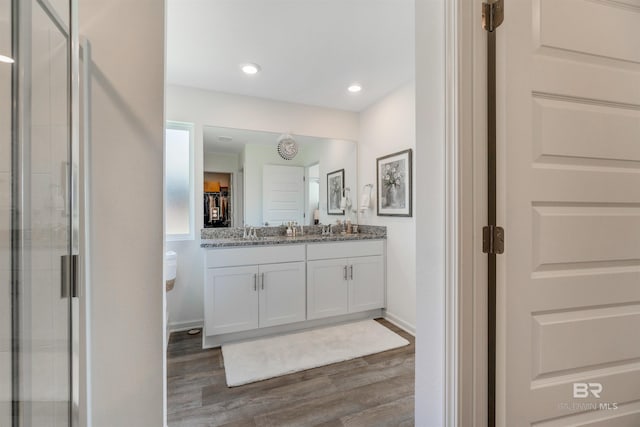 bathroom with vanity, wood-type flooring, and a shower with shower door