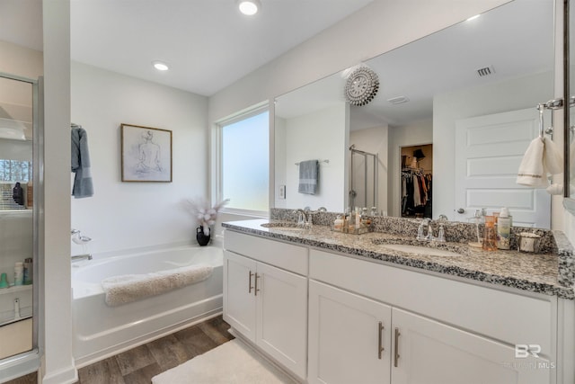 bathroom featuring hardwood / wood-style floors, vanity, and plus walk in shower