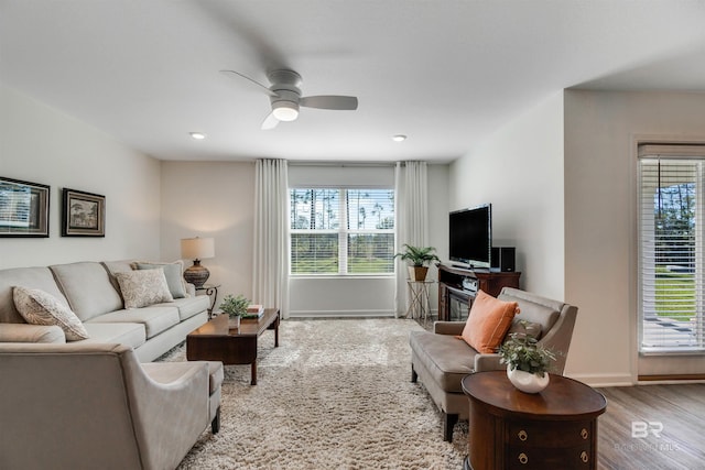 living room featuring ceiling fan, plenty of natural light, and light hardwood / wood-style flooring