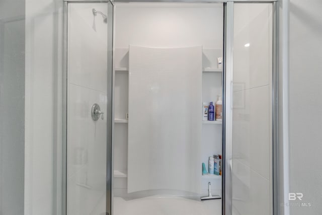 bathroom with a shower with door