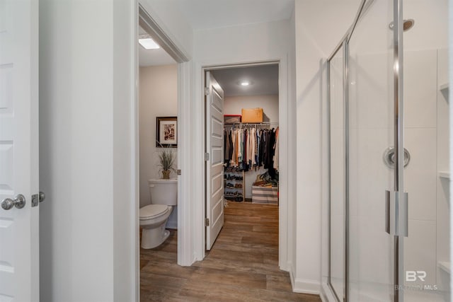 bathroom with toilet, hardwood / wood-style floors, and walk in shower