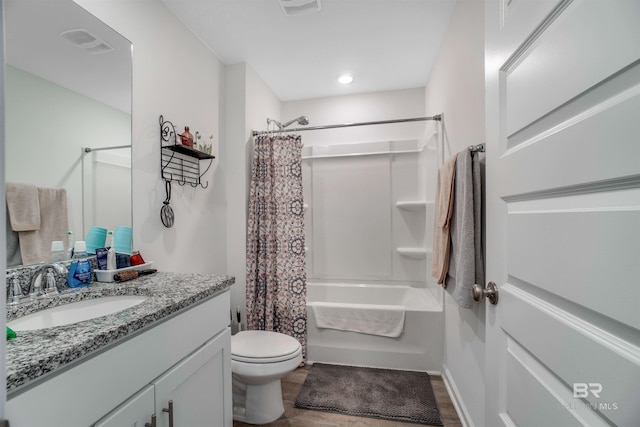 full bathroom with vanity, toilet, wood-type flooring, and shower / tub combo